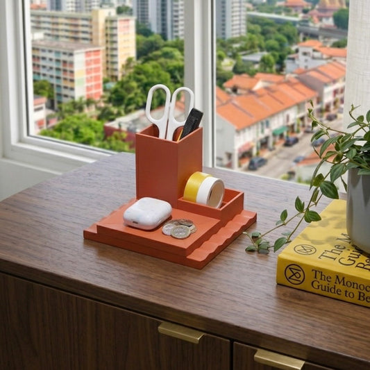 Orange desk organizer with stationery items on a wooden desk with a cityscape view.