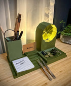 Green desk organizer with various items on a wooden surface