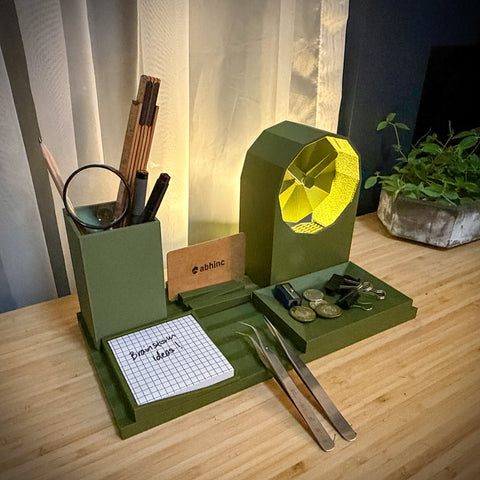 Green desk organizer with various items on a wooden surface