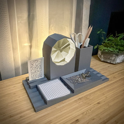 Gray desk organizer with geometric design on a wooden surface